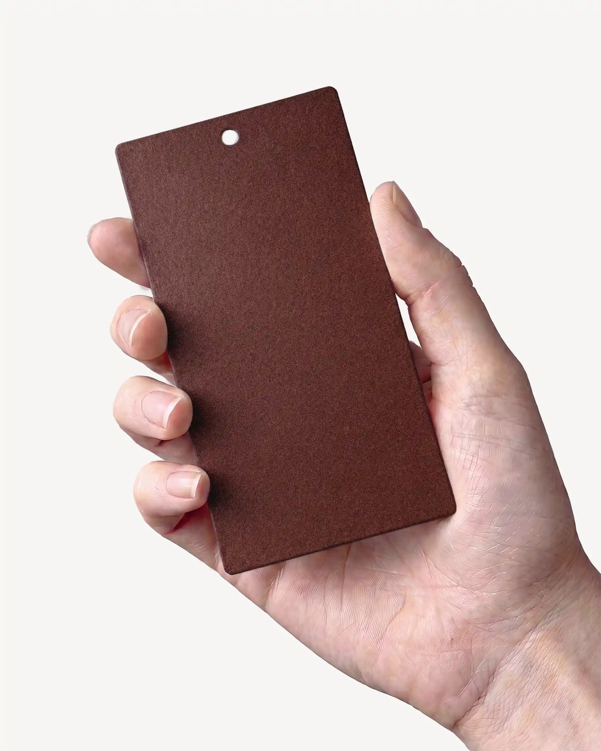 Hand, das ein Muster in der Farbe Rostbraun PILOTIS hält