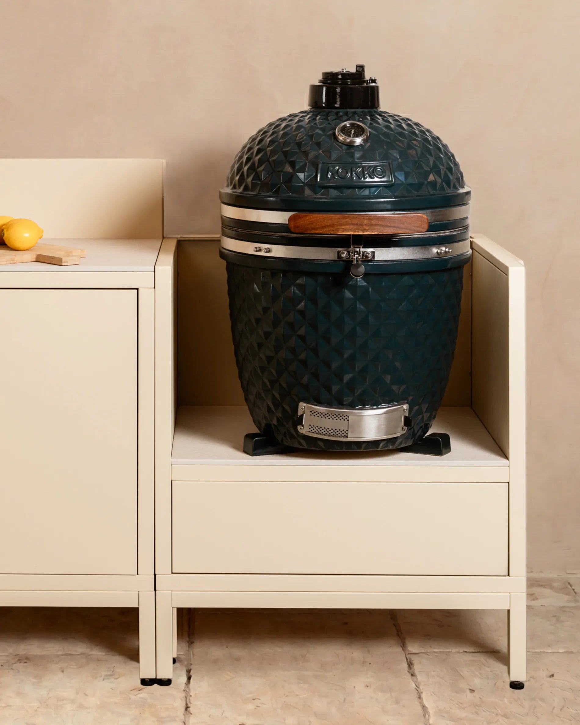 Marineblauer Kamado-Grill von Kokko, eingebaut in das cremebeige PILOTIS-Modul – für Ihre stilvolle Outdoor-Küche