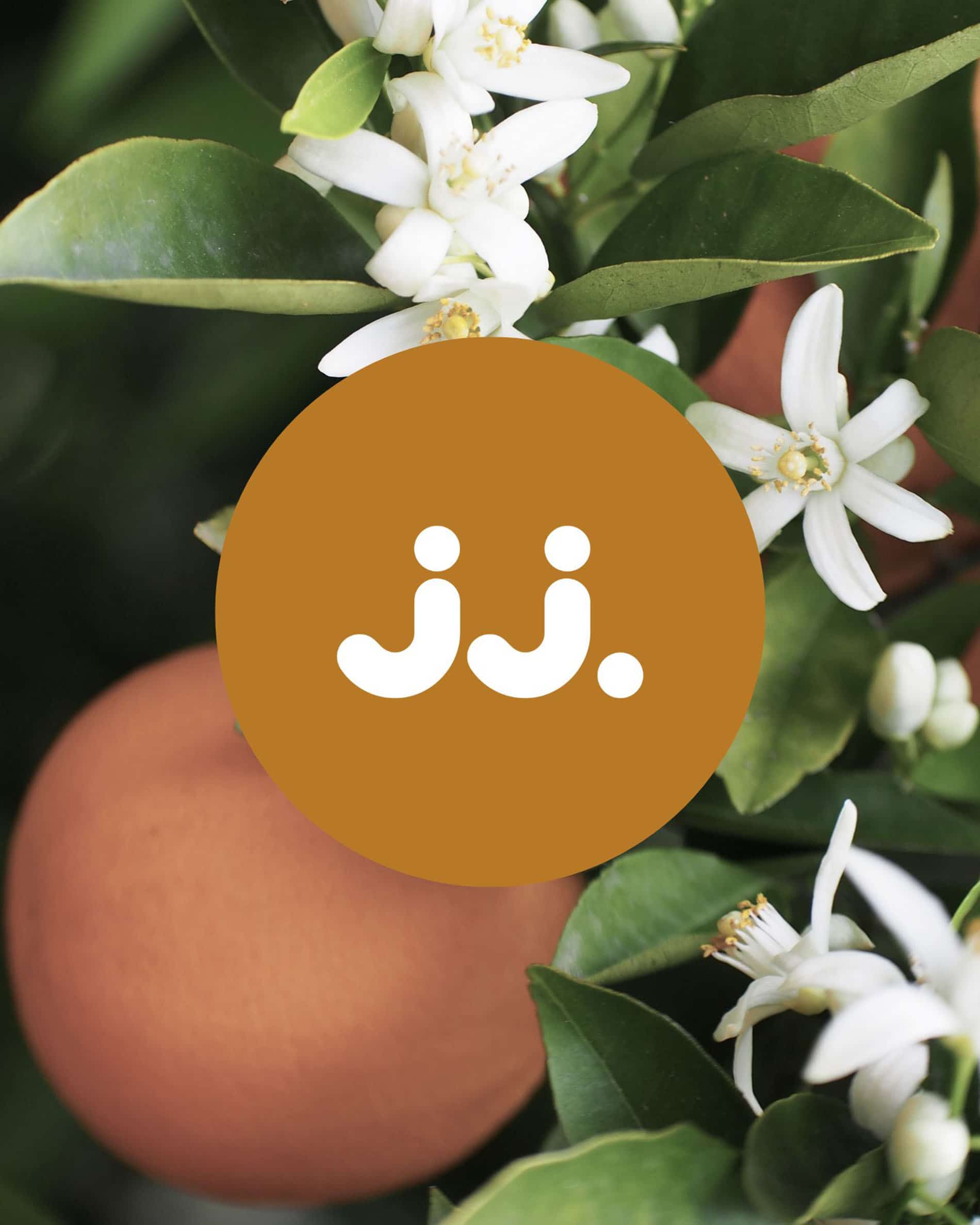Orangenblüten und orangefarbene Früchte mit jj.-Logo, für den Duft Zitronengras & Orangenblüte.