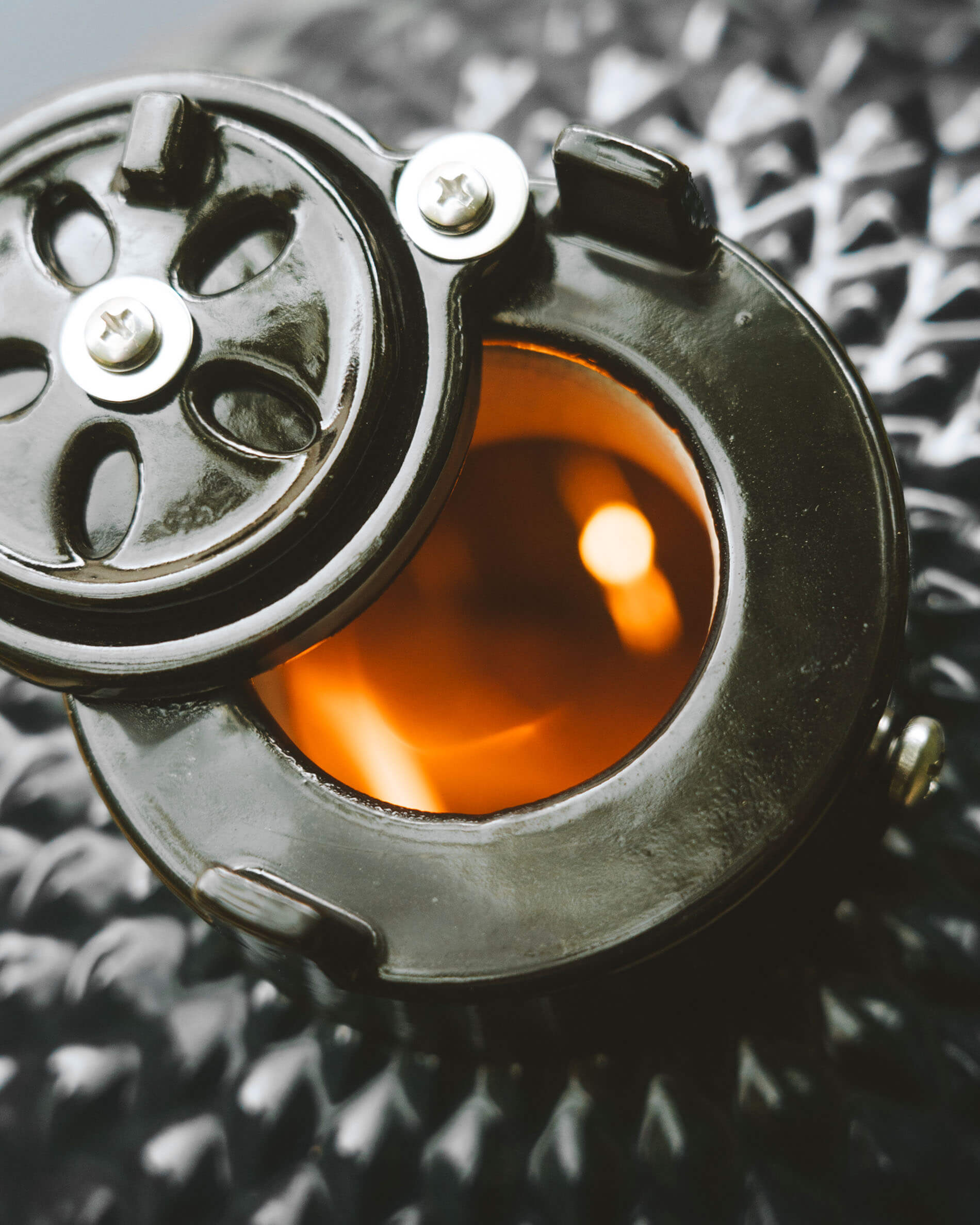 Nahaufnahme des oberen Belüftungssystems eines Kokko Kamado mit runder Öffnung und sichtbarem, glühendem Feuer.