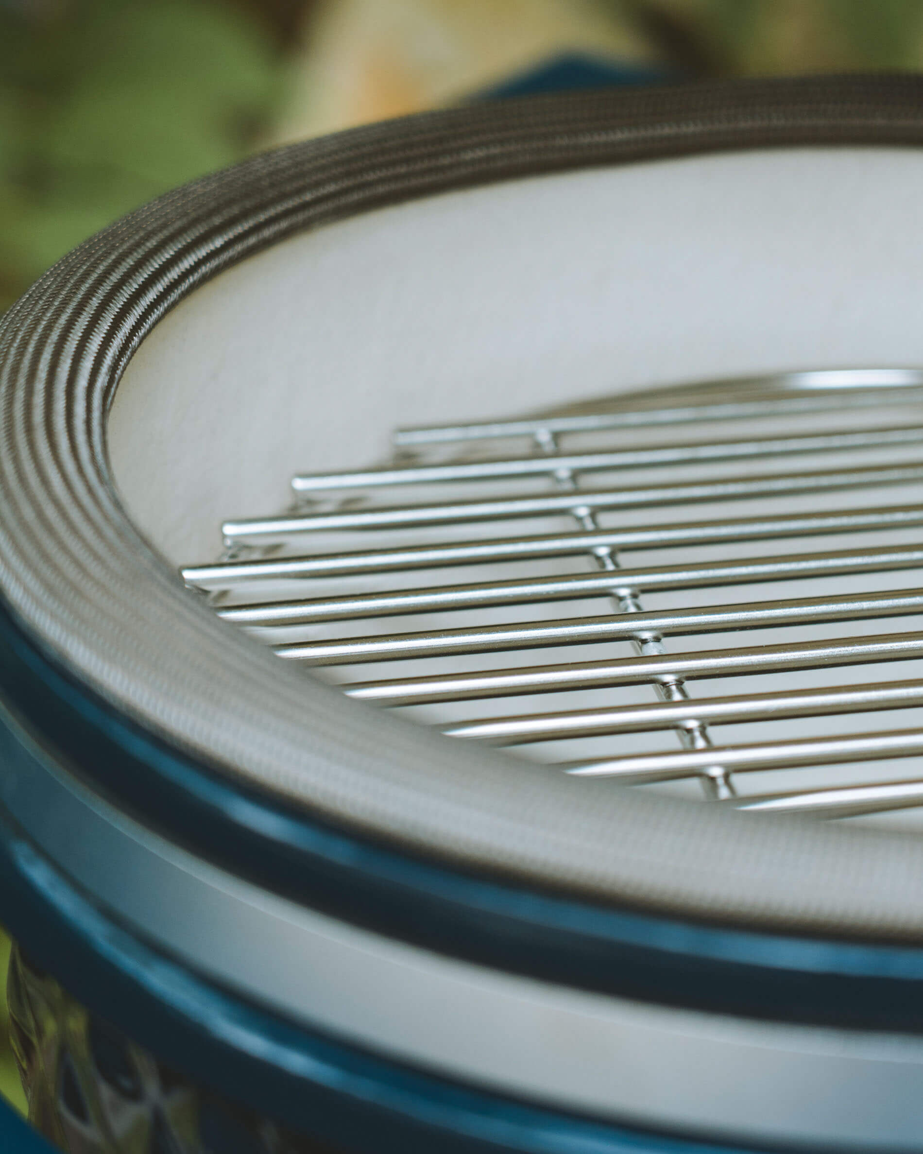 Detailaufnahme des Edelstahl-Grills und der Deckeldichtung eines Kokko Kamado in der Farbe Ozean.