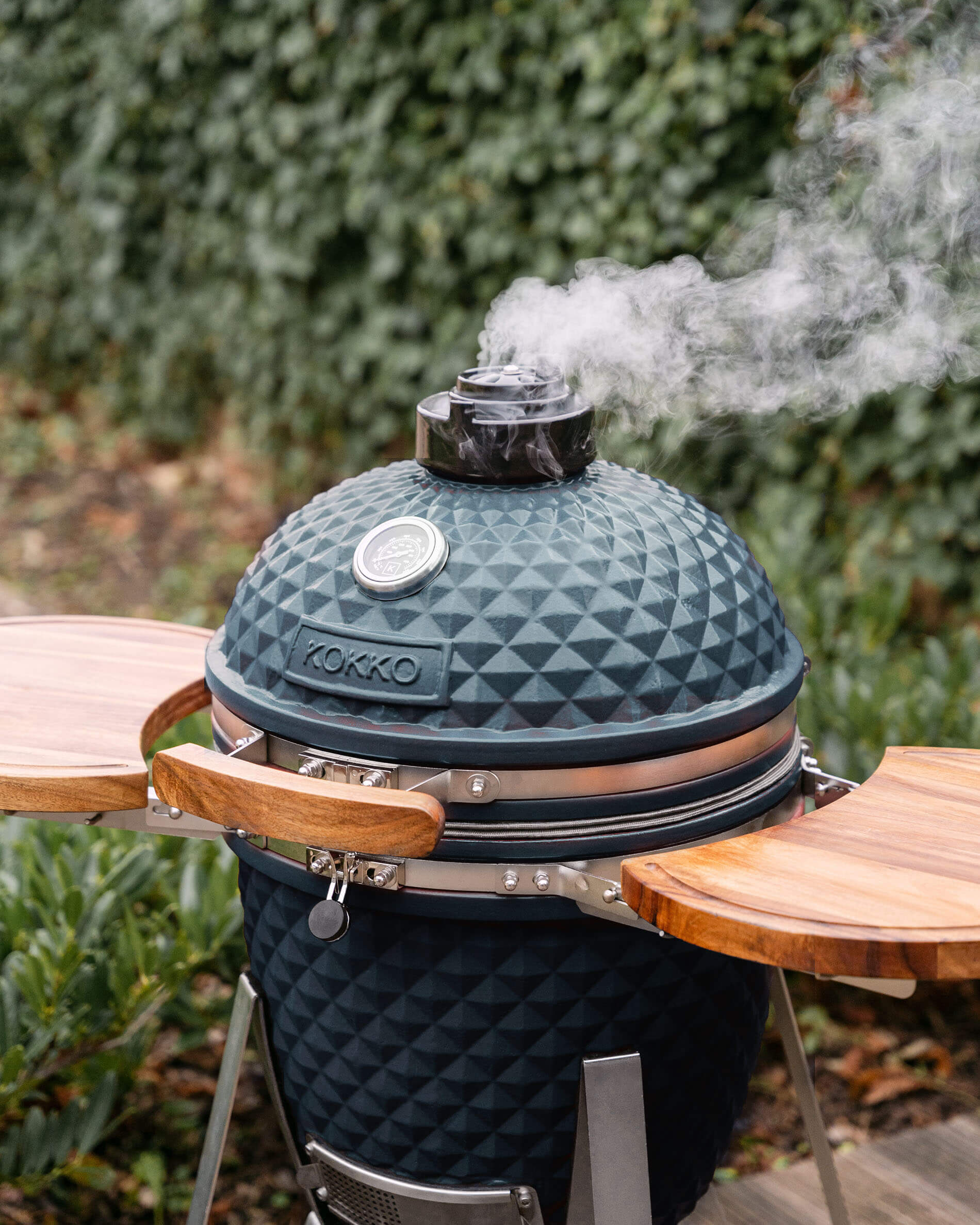 Kamado-Grill Kokko L 18 Zoll aus Keramik in Ozeanblau im Außenbereich installiert.