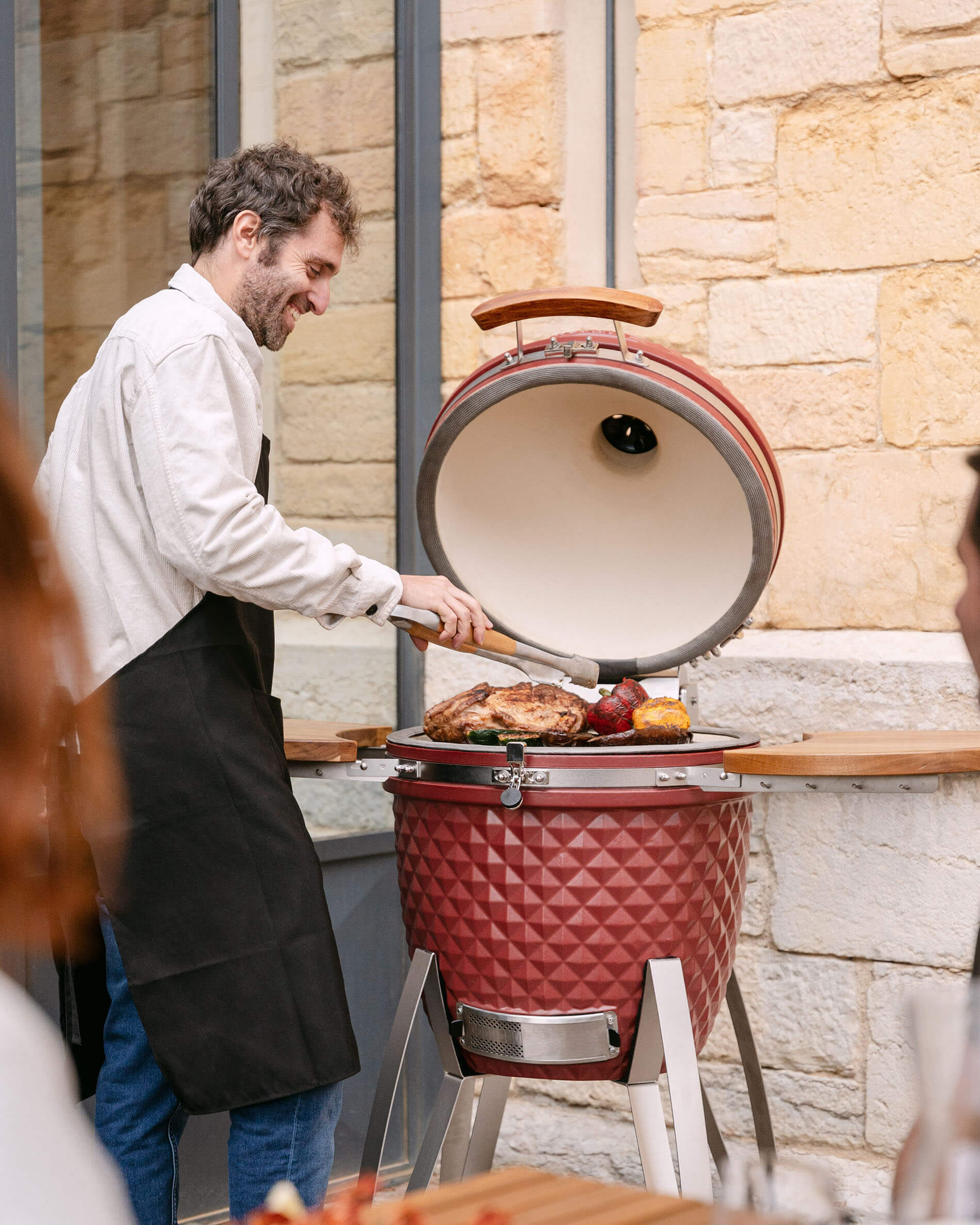 Kamado Kokko aus roter Oxid-Keramik im Einsatz beim Grillen.