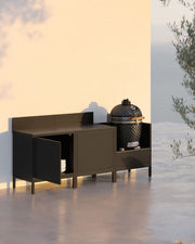 Outdoor-Küche auf Stelzen mit 3 Modulen, Kamado, schwarzem Möbel und geöffneter Aufbewahrungstür.