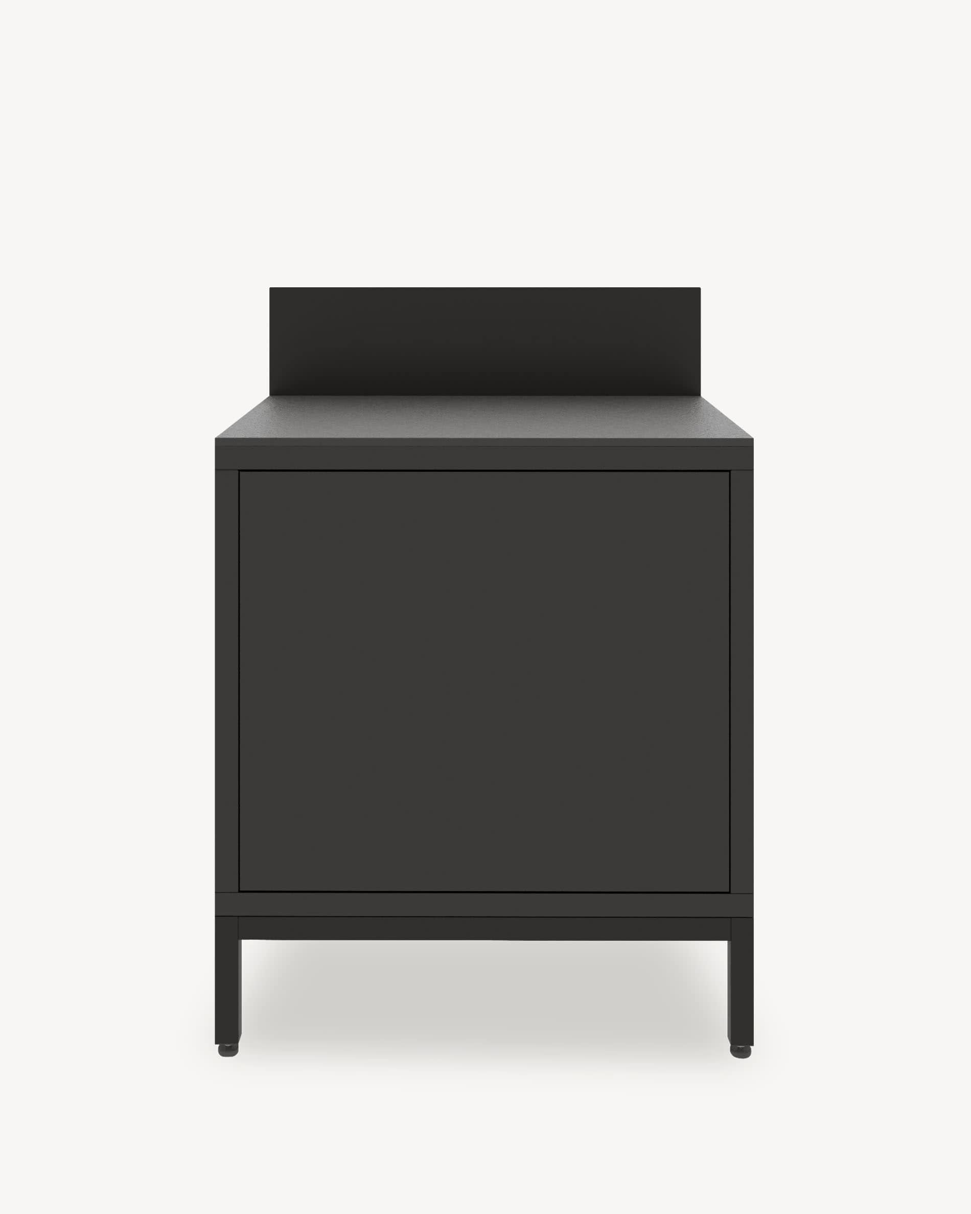 Küchenmodul auf Stelzen mit geschlossenem Stauraum, Front in Schwarz, dunkle Arbeitsplatte und integrierte Rückwand.