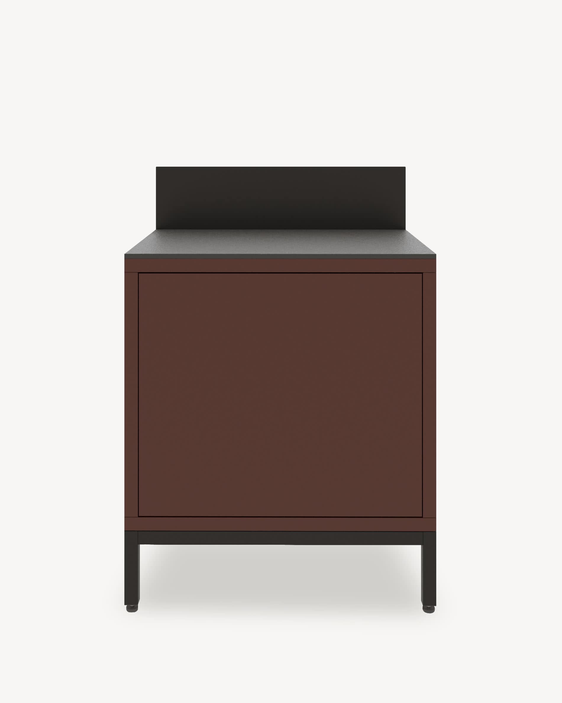 Küchenmodul auf Stelzen mit geschlossenem Stauraum, Front in Rostbraun, dunkle Arbeitsplatte und integrierte Rückwand.