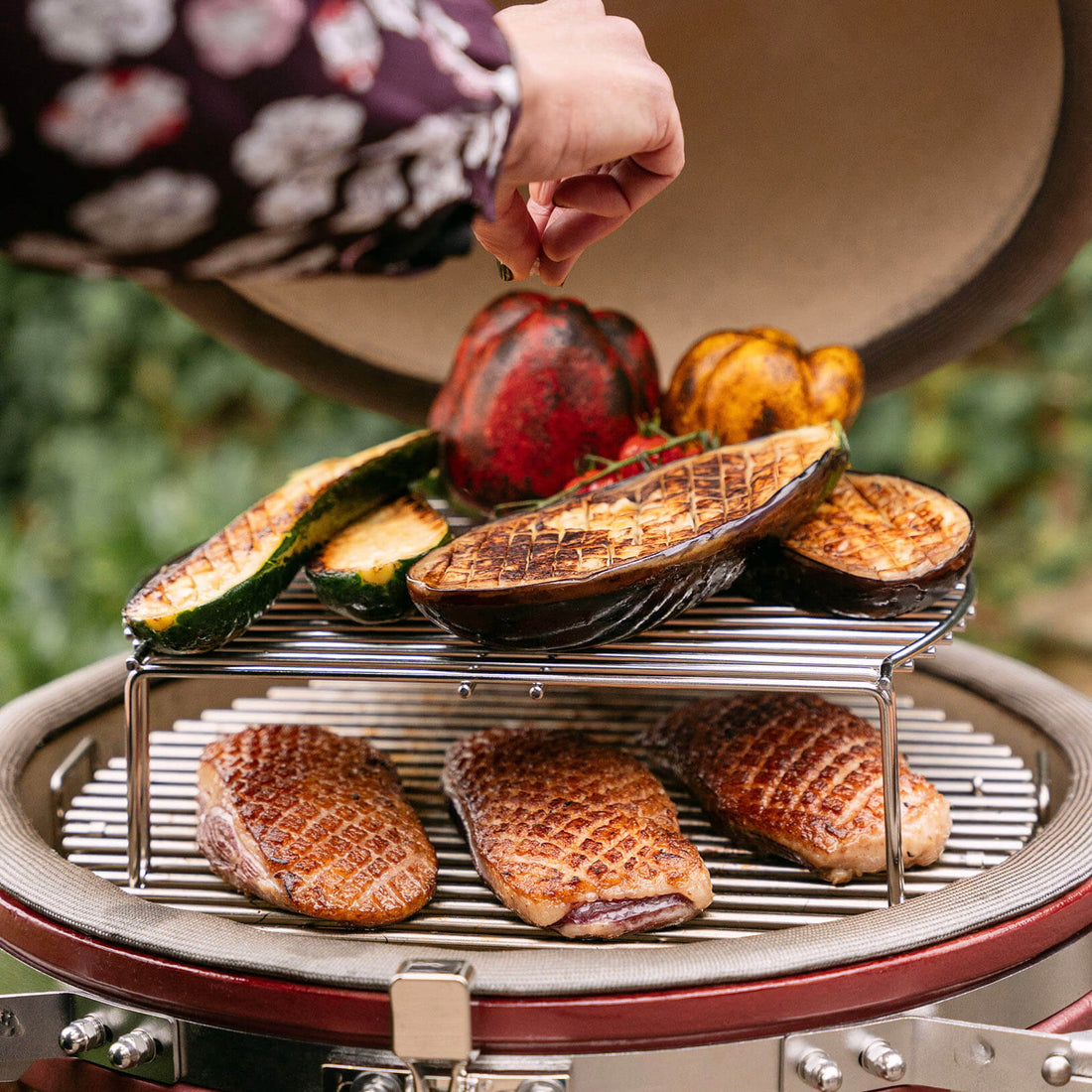 Kamado Kokko 18 Zoll im vielseitigen Einsatz, zeigt die gleichzeitige Zubereitung verschiedener Speisen dank präziser Temperaturkontrolle und indirektem Grillen.