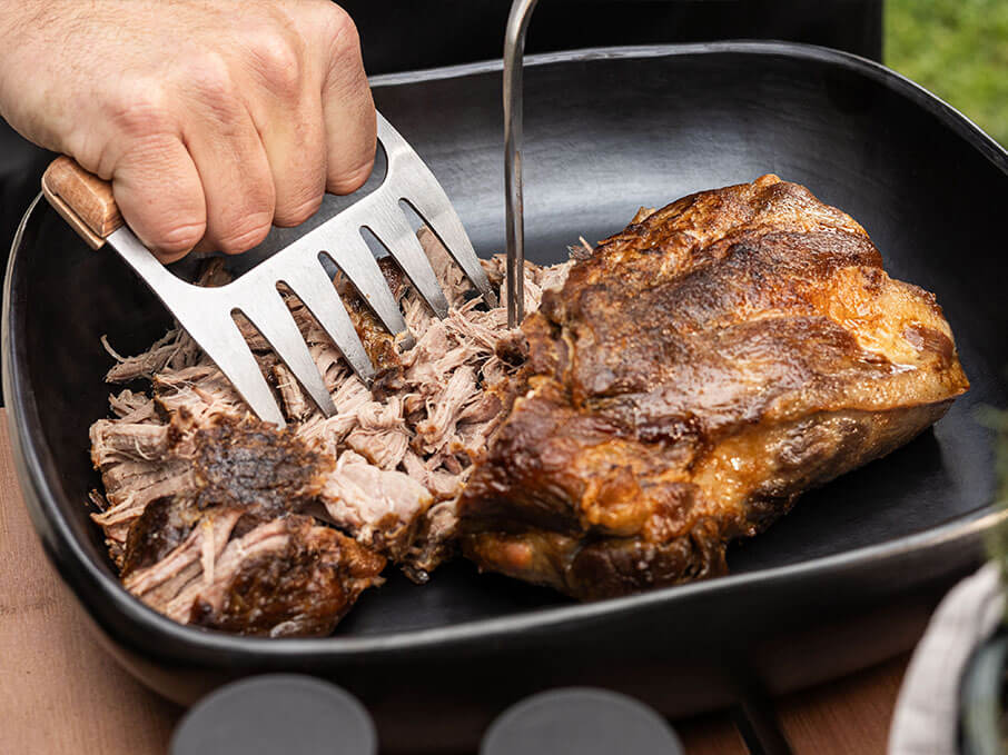 Pulled Pork aus dem Kamado-Grill von Kokko, zeigt die zarte Fleischstruktur nach langsamem Garen.