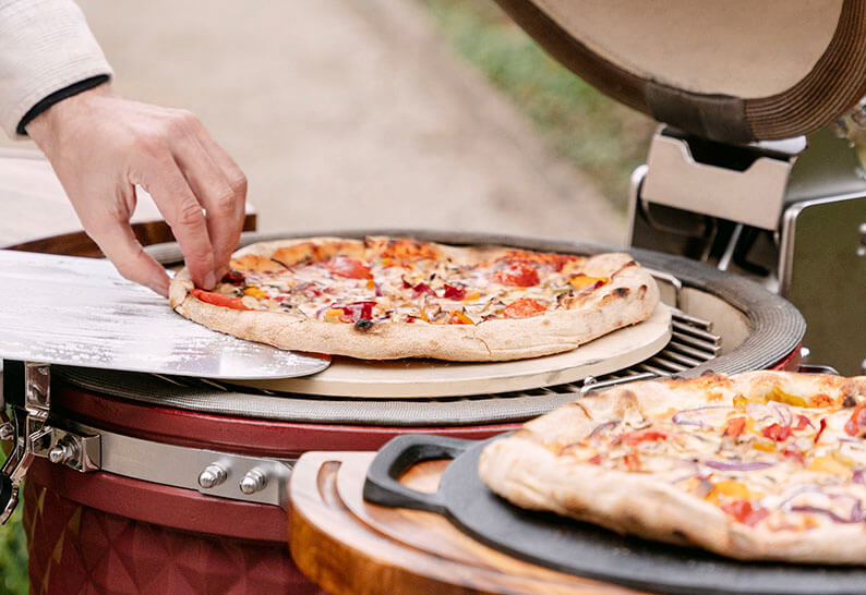 Pizzen beim Backen im Kokko Kamado, indirektes Garen auf einem Pizzastein.